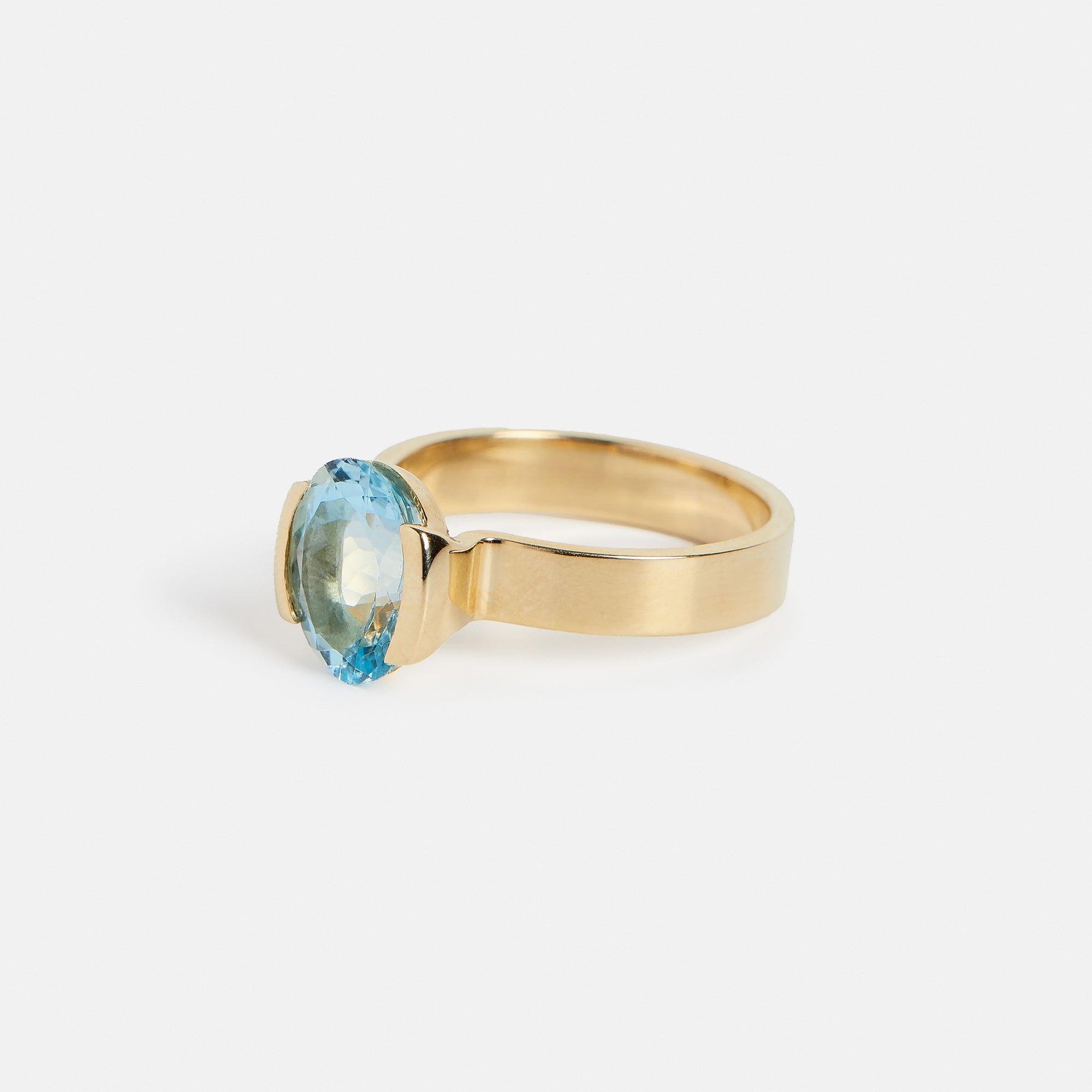 Cool Tension Set Half Bezel Engagement Ring with blue aquamarine gemstone in 14k yellow gold by SHW famous fine jewelry store in NYC