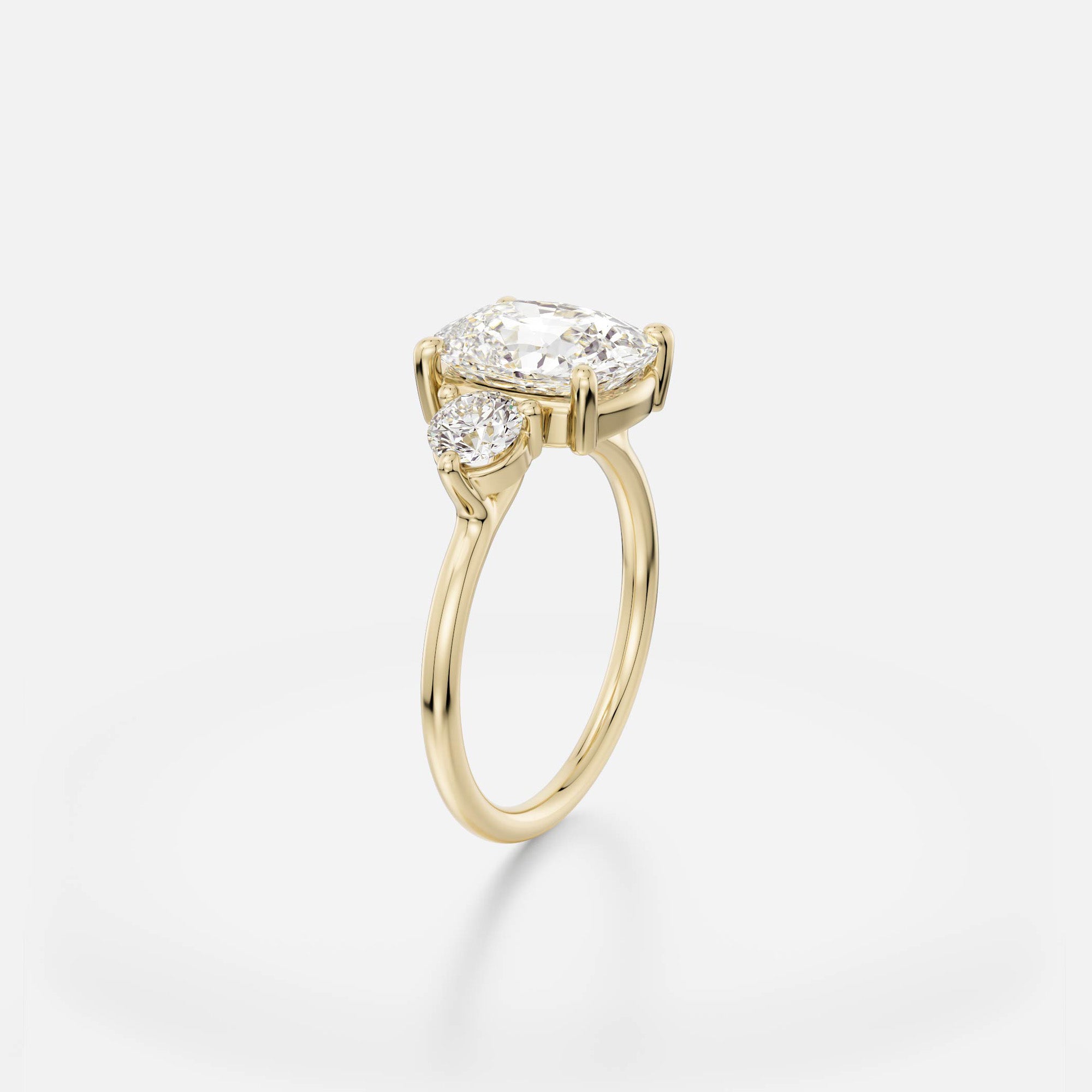 Kala elongated cushion diamond three stone engagement ring with round side stones angle view in 14 karat yellow gold