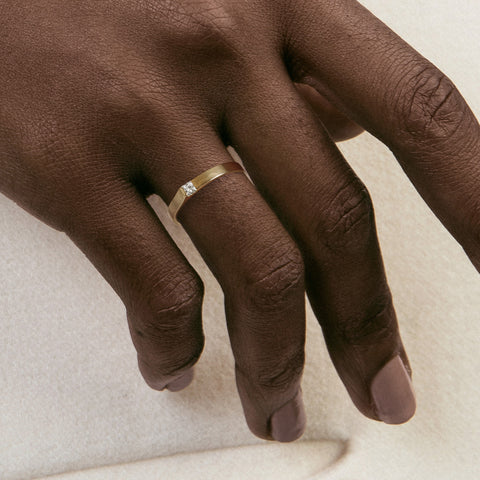 2.5mm flat gold band with princess-cut diamond shown worn in natural light