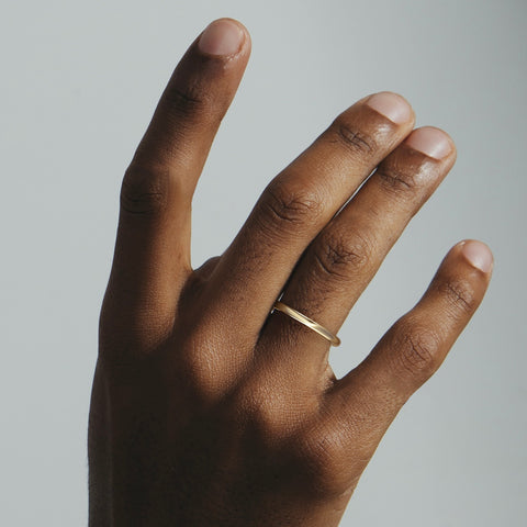 Architectural gold ring with baguette diamond worn on hand