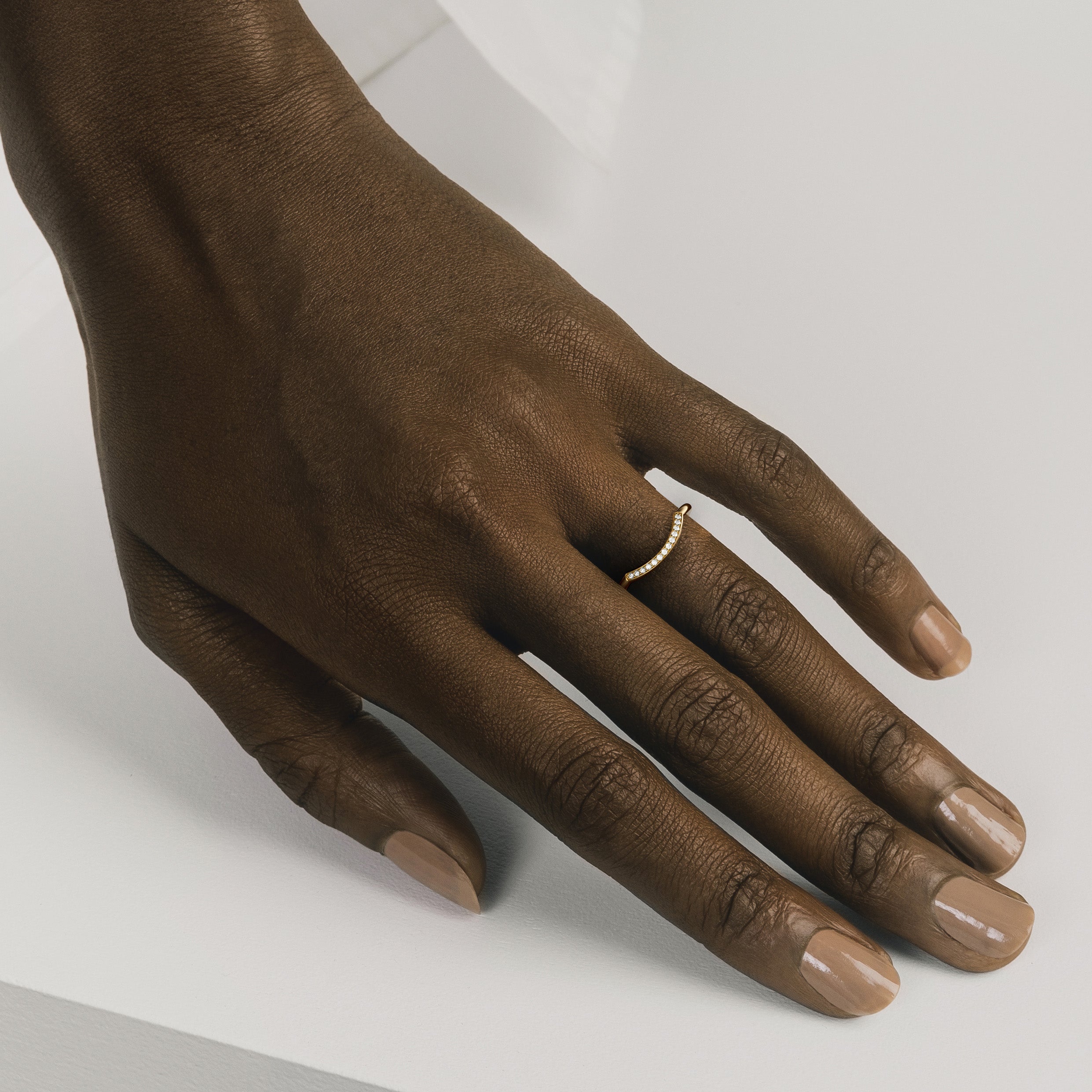 Curved diamond wedding band shown worn in natural light