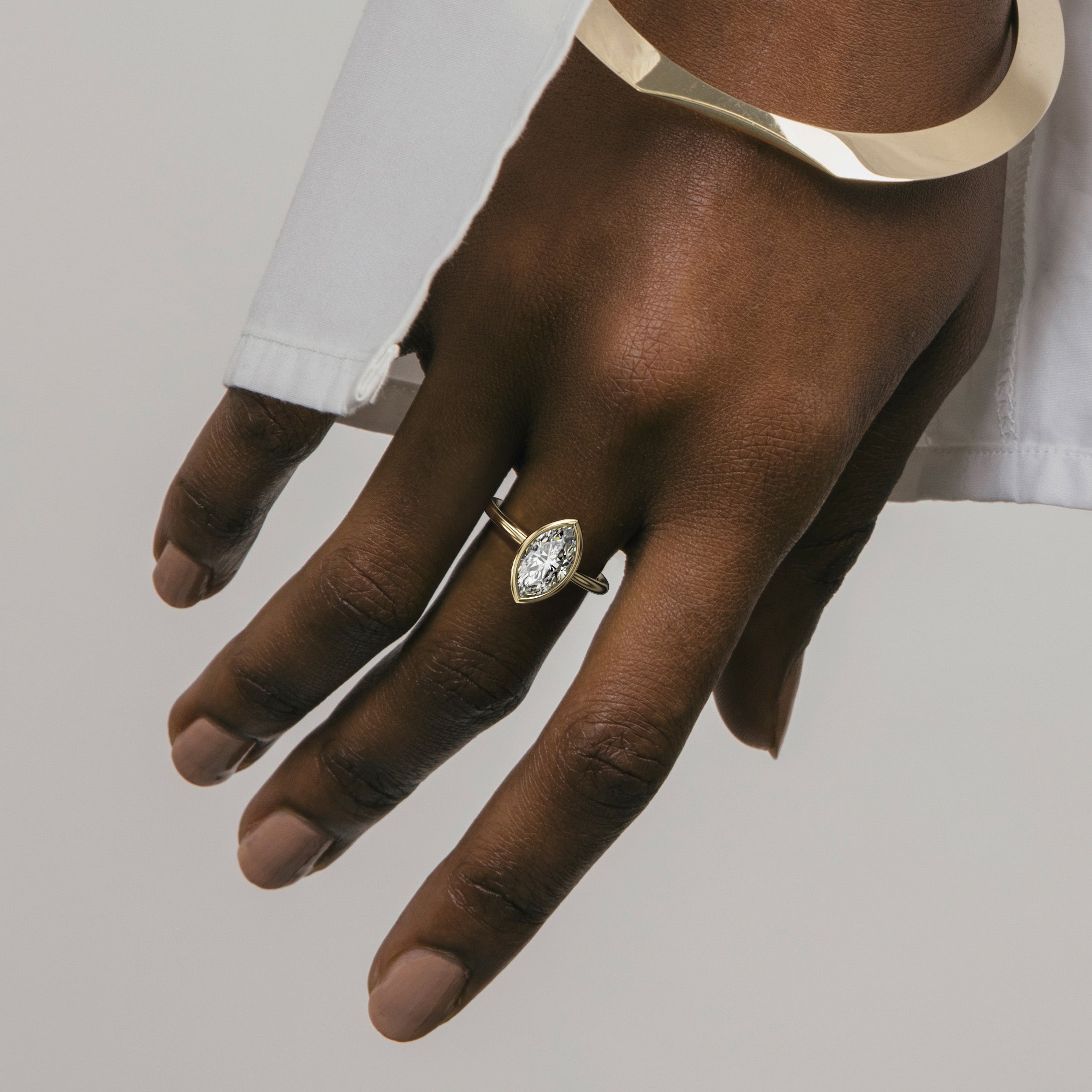 Close view of marquise diamond in thin bezel on slim round profile band