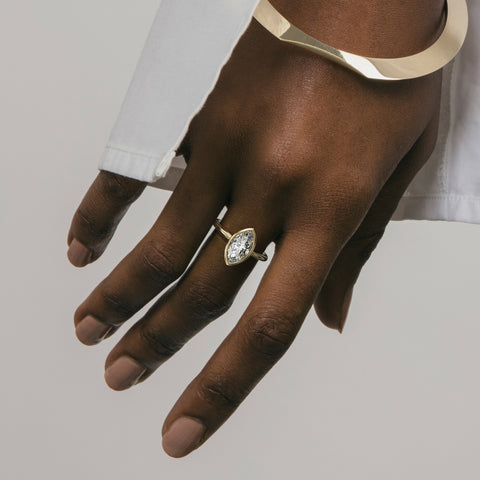 Close view of marquise diamond in thin bezel on slim round profile band