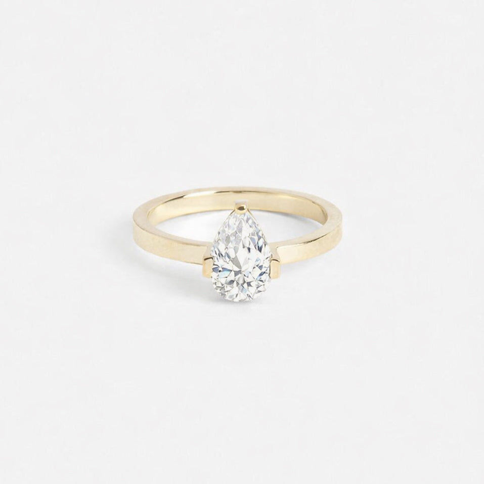 14k yellow gold engagement ring with 1.30 carat pear-cut diamond in minimalist three-prong setting on thin flat band