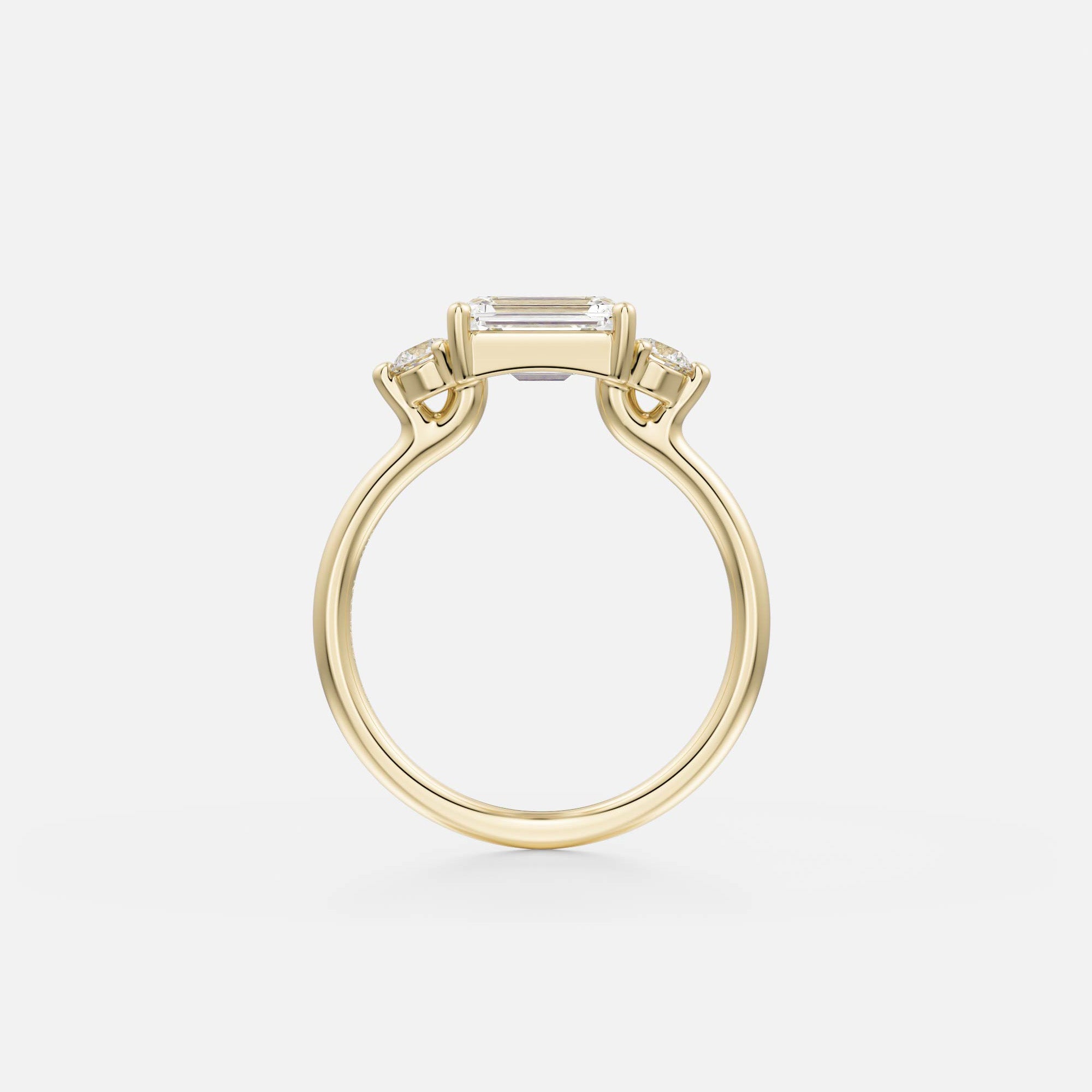 14 karat yellow gold engagement ring with emerald-cut center diamond set east-west in corner prongs and round side diamonds