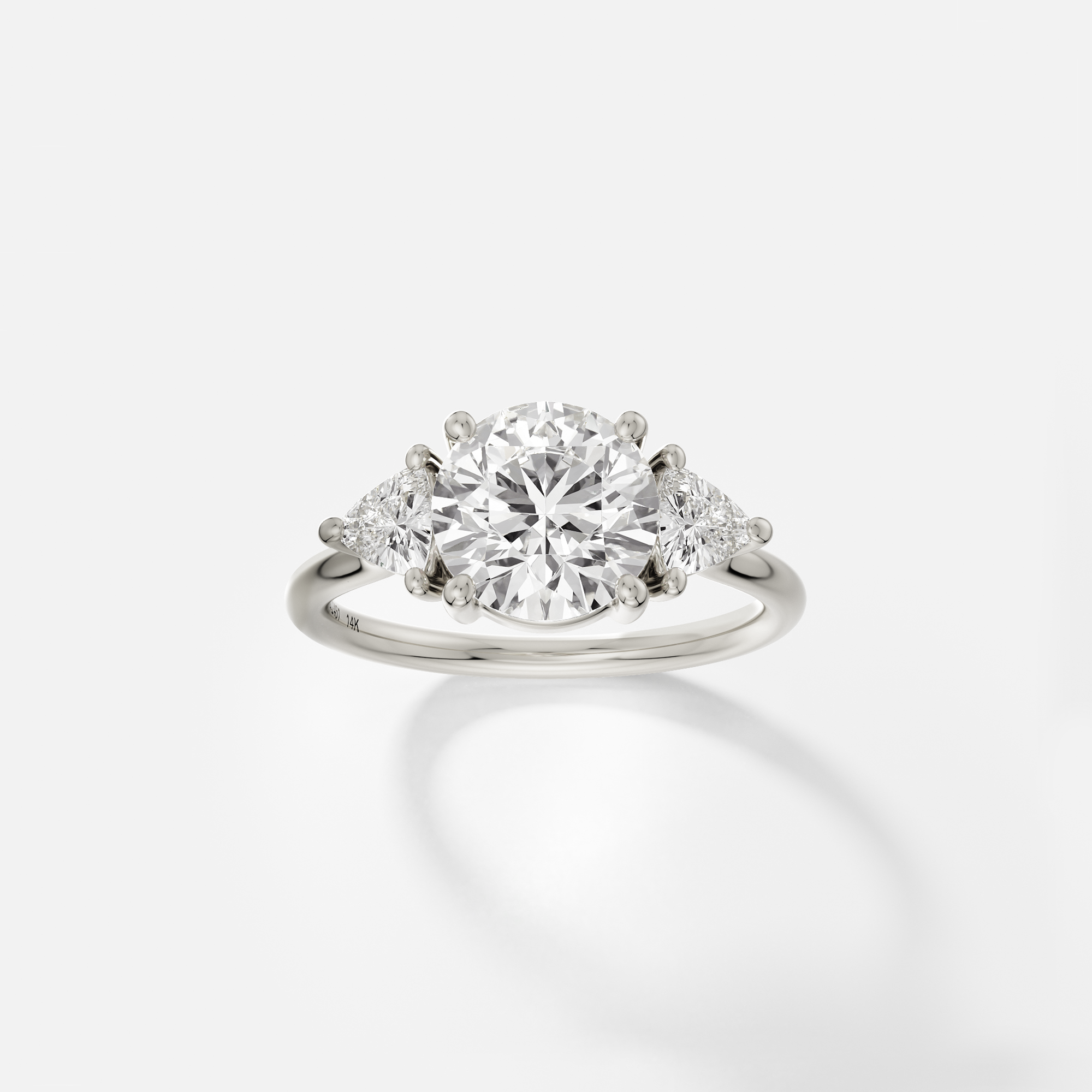 14k white gold engagement ring with 2.00 ct round brilliant diamond and trillion side stones in prong setting