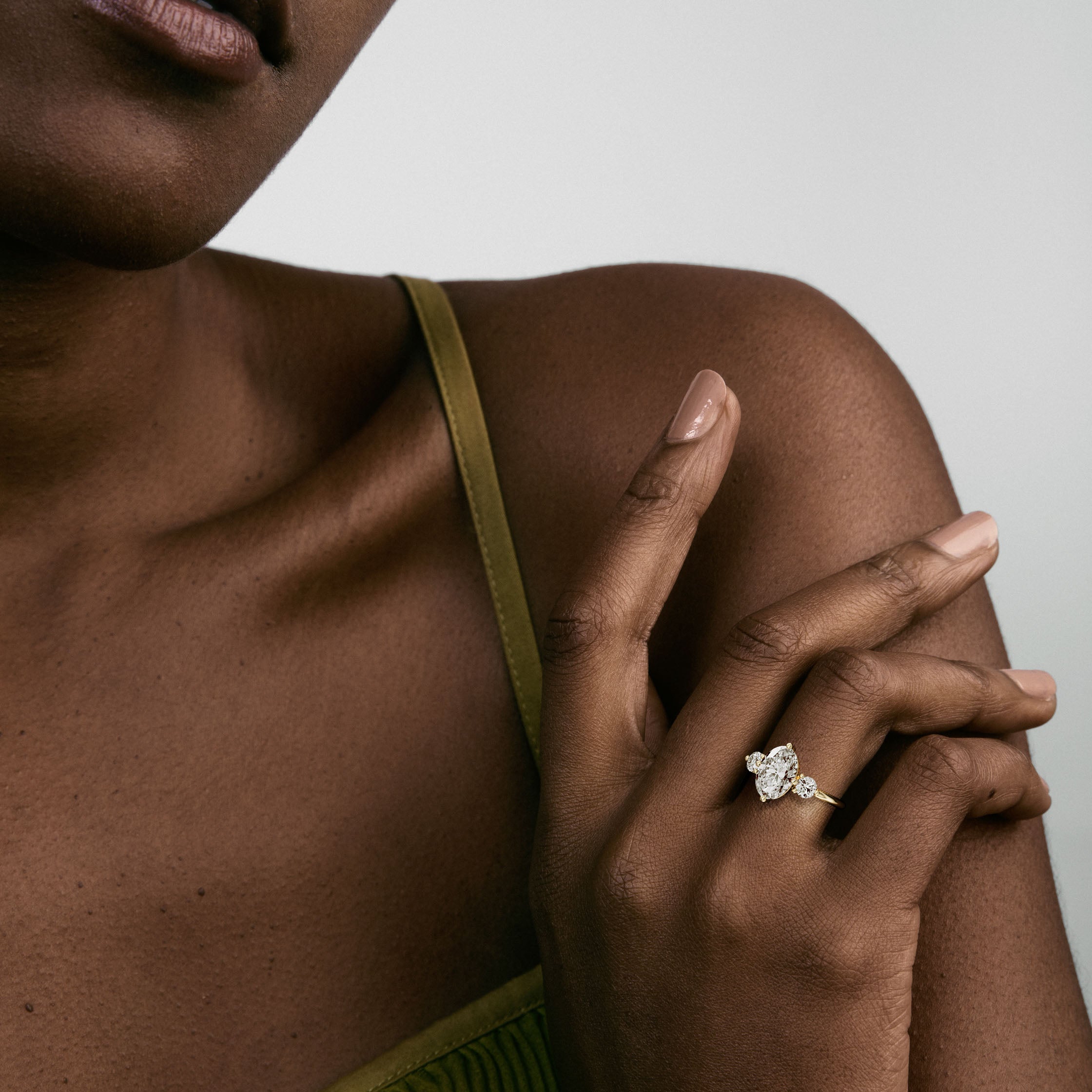 Kele oval diamond three stone engagement ring worn on hand