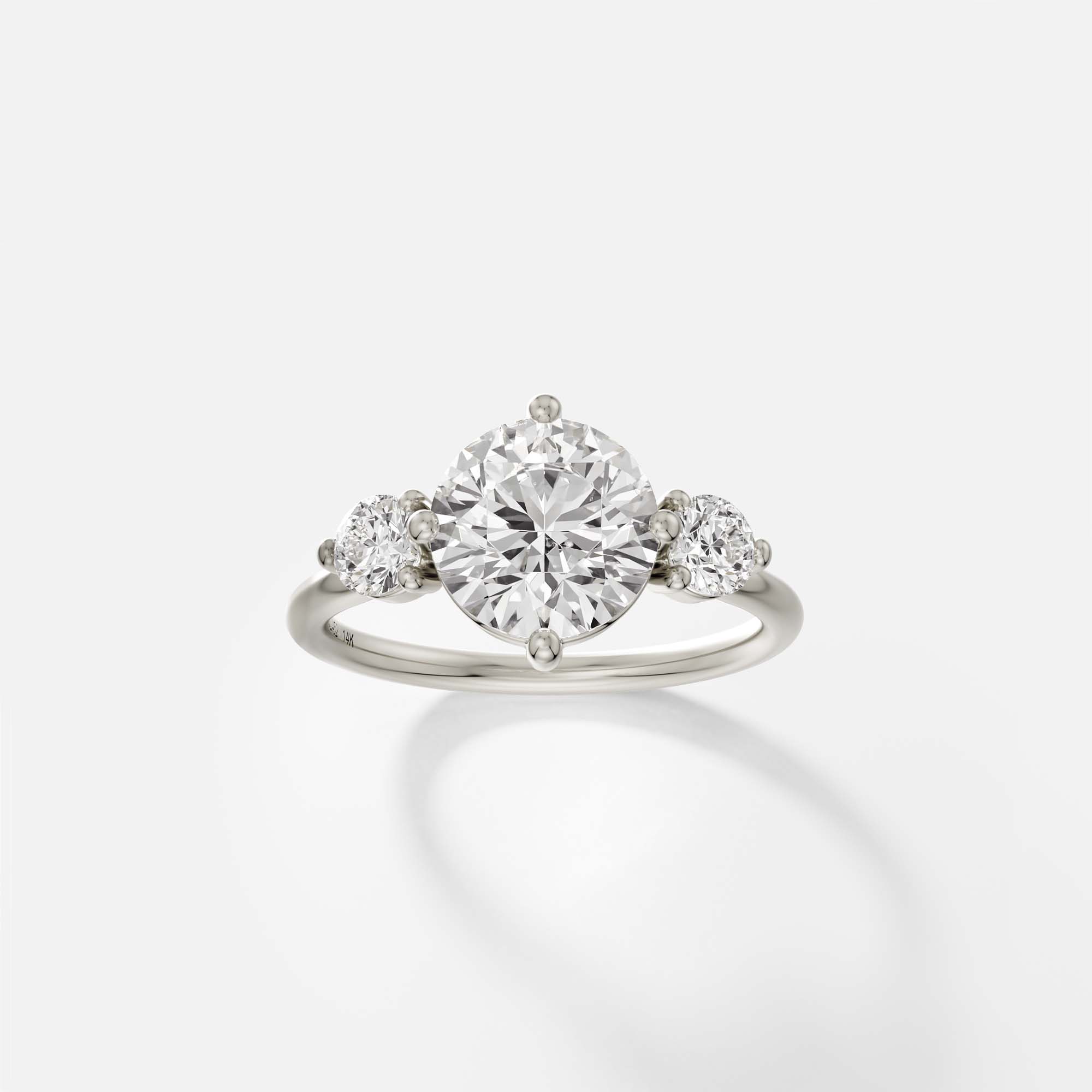 14k white gold three stone engagement ring with round brilliant diamond center and round side stones in prong setting