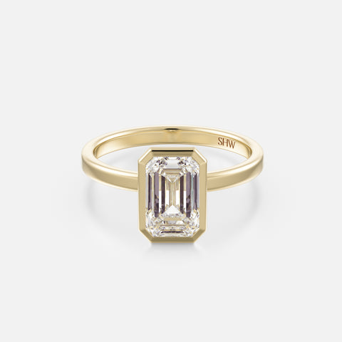 14k yellow gold thin flat band engagement ring with 2 carat emerald-cut diamond in bezel setting
