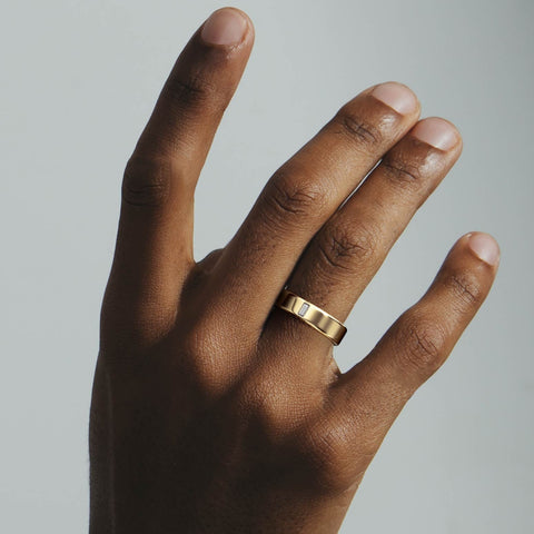 Minimal diamond wedding band with an embedded baguette stone shown worn in natural light