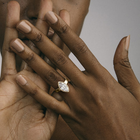 Close view of marquise diamond in thin bezel on wide flat band