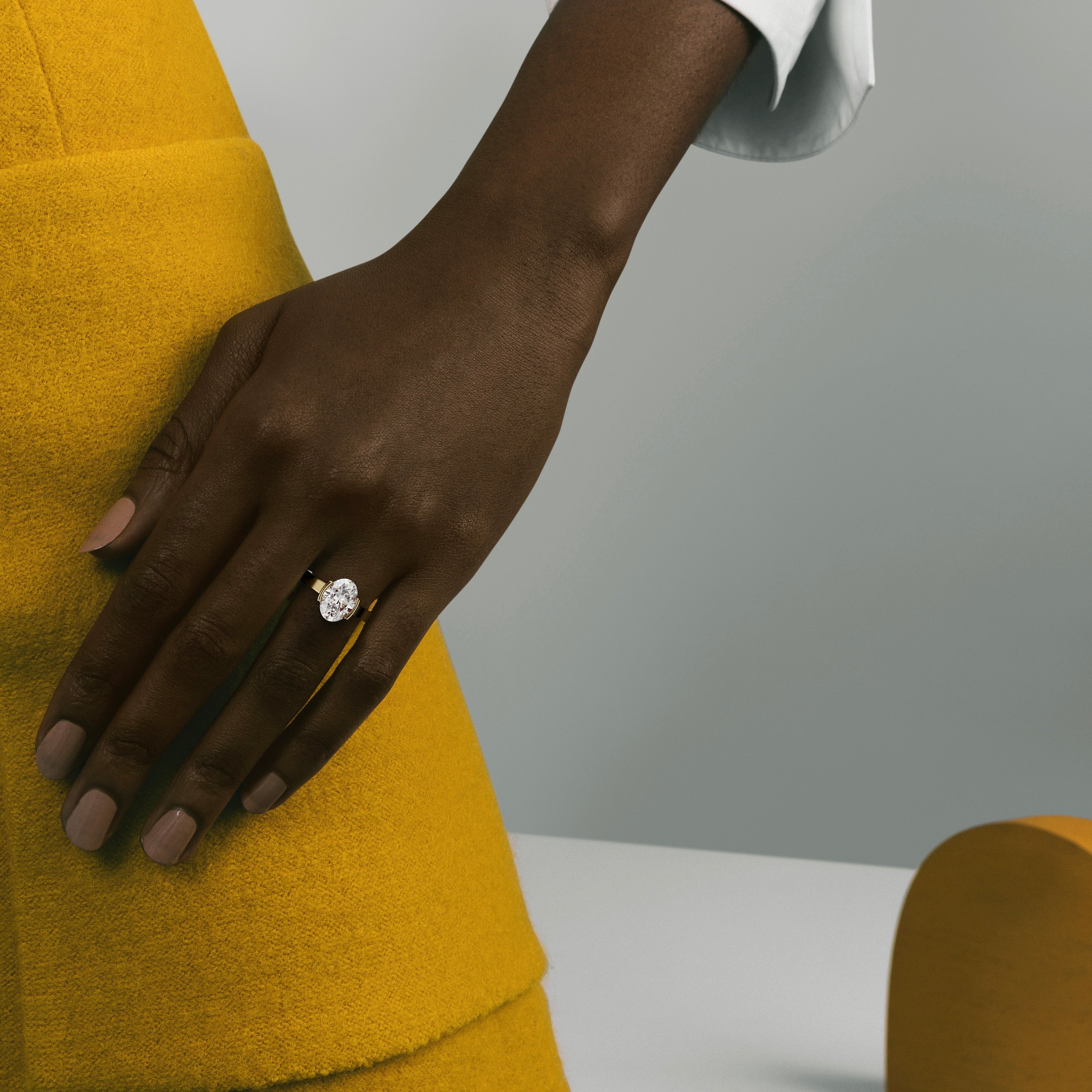 3 carat oval diamond engagement ring in tapered partial bezel setting worn on hand