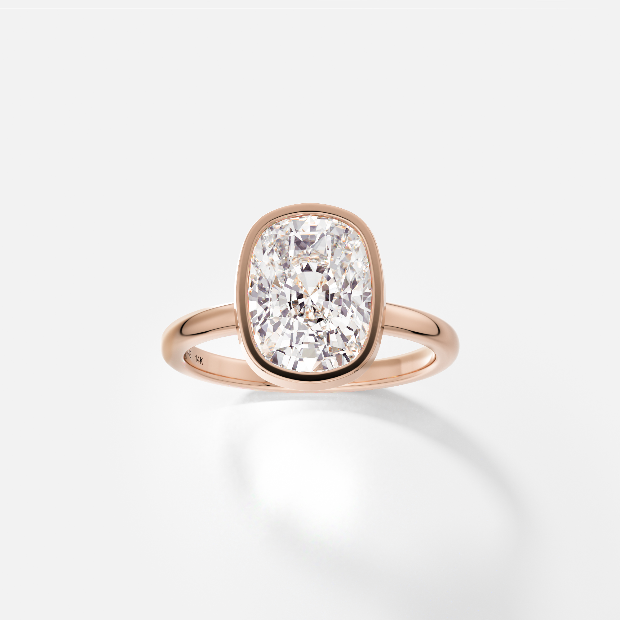 14k rose gold engagement ring with 3.50 carat elongated cushion diamond bezel set on 2mm domed band