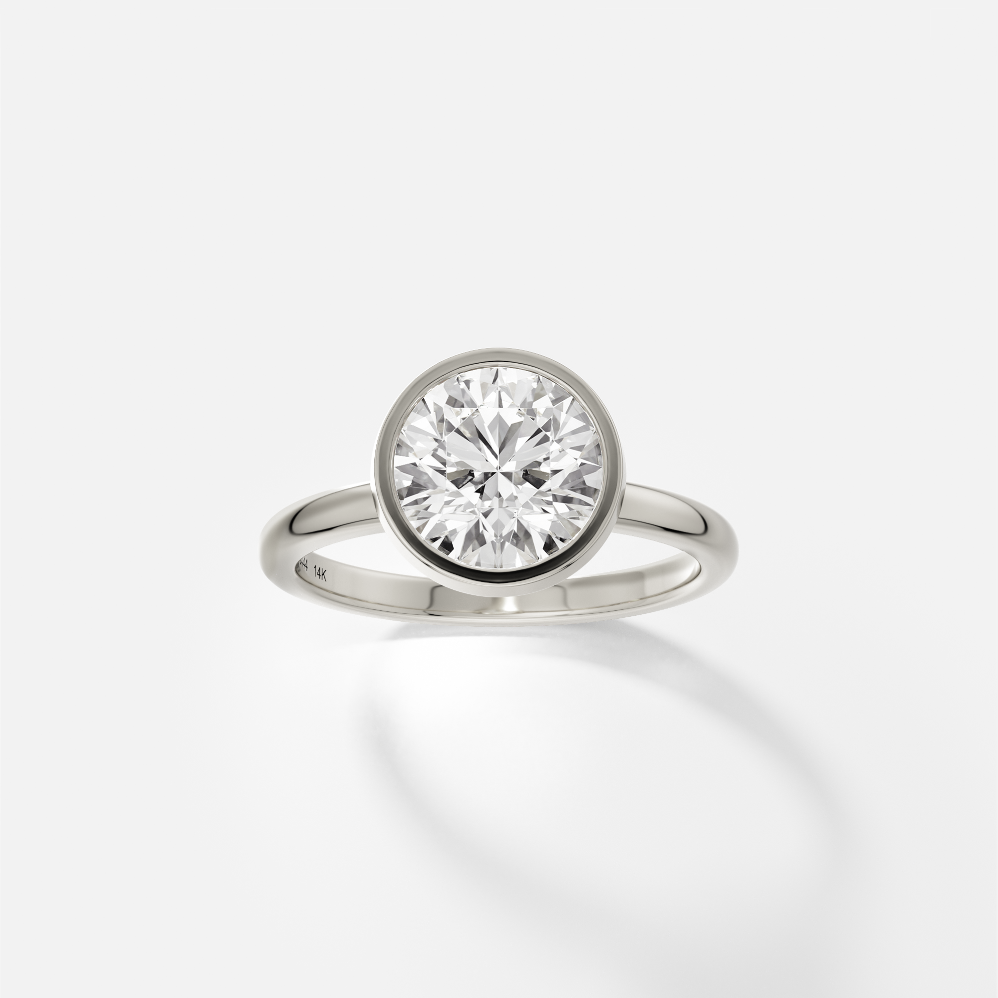 14k white gold engagement ring with 2.00 ct round brilliant diamond in thin bezel setting on domed band