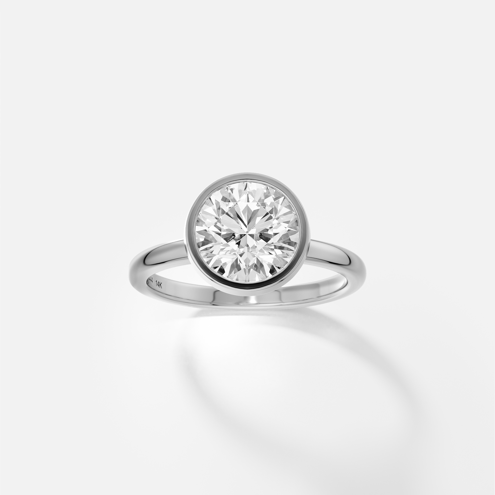 platinum engagement ring with 2.00 carat round brilliant-cut diamond set in minimal bezel on domed band