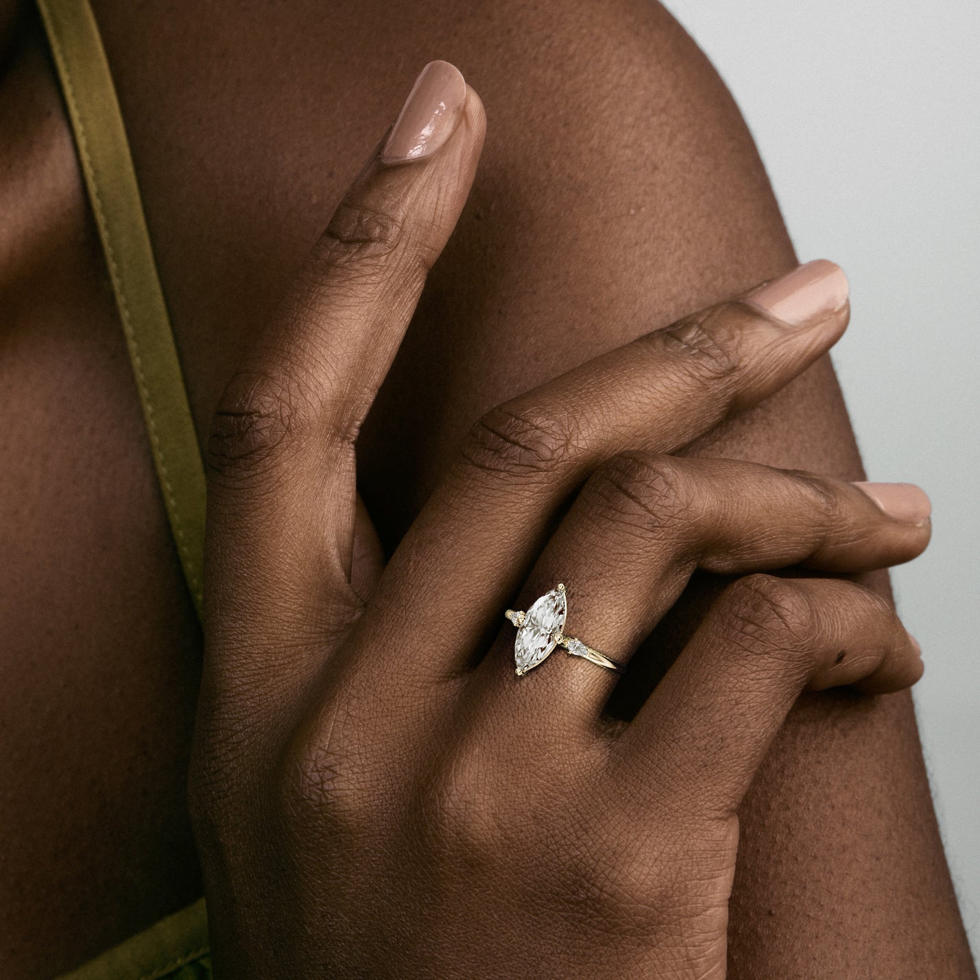 Close view of marquise diamond three stone engagement ring with pear-cut accent stones on delicate round band