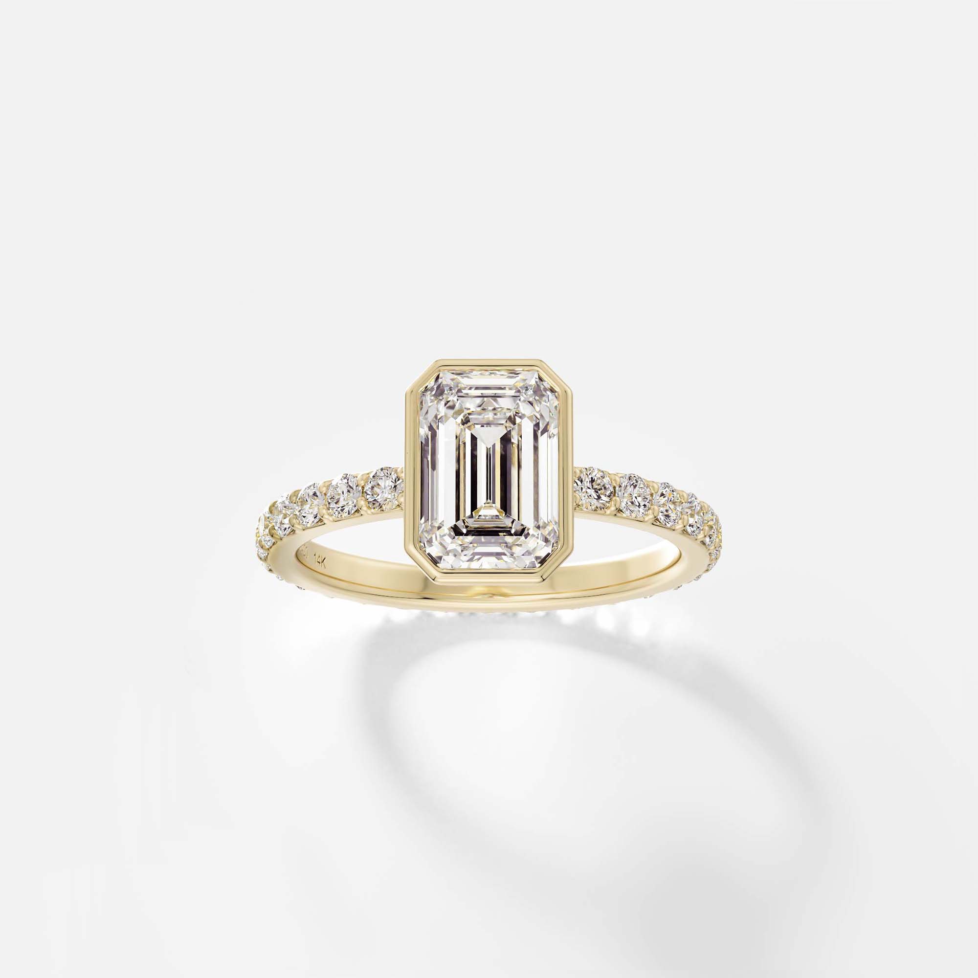 Modern bezel set emerald-cut step-cut diamond engagement ring with pavé diamond half eternity band