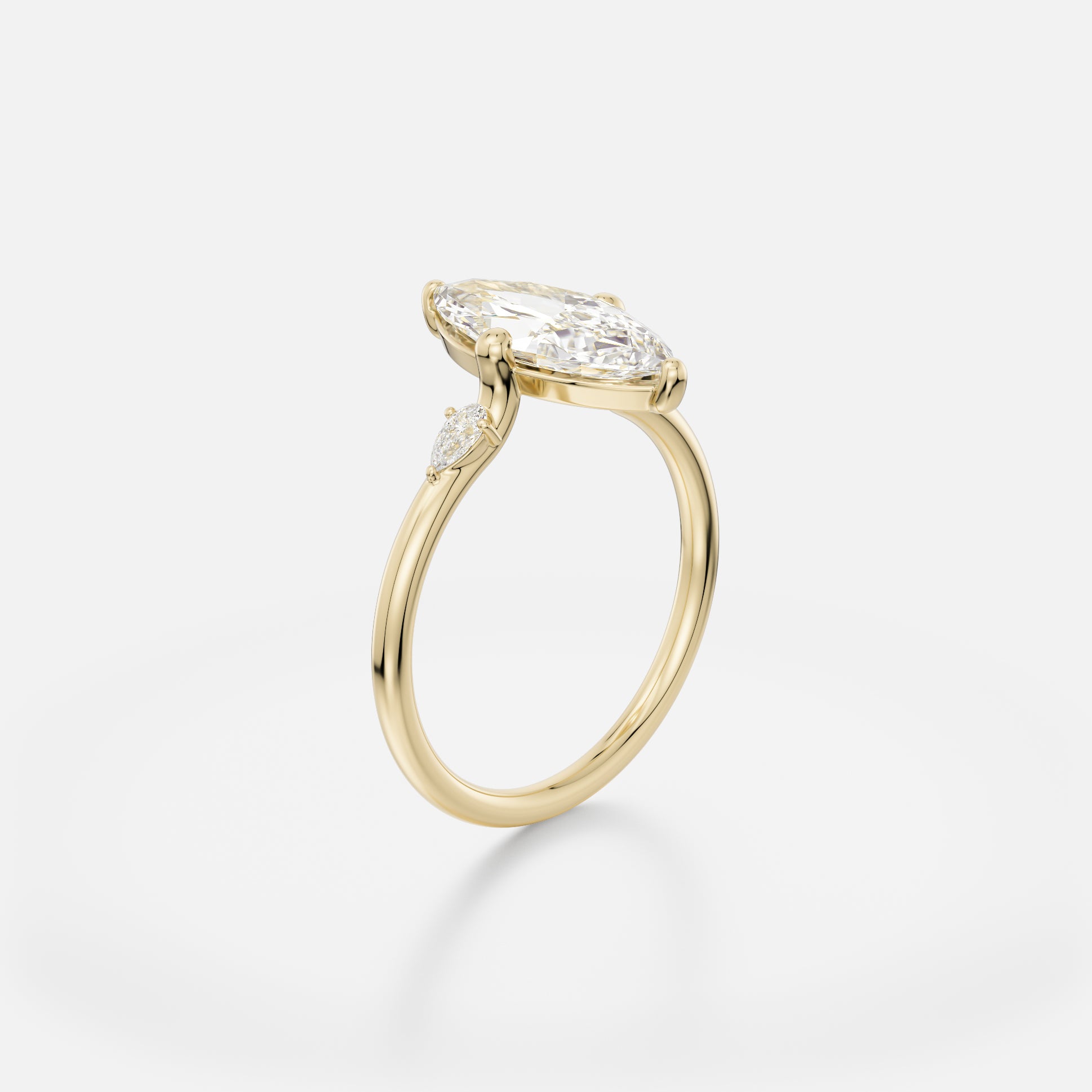 Delicate round profile band engagement ring with marquise diamond set north-south in compass prongs and pear side stones