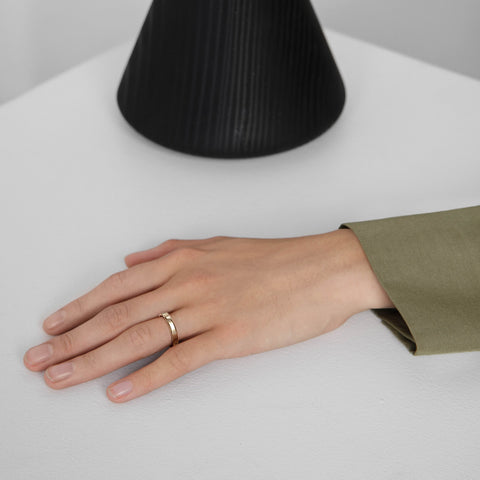 Minimal diamond band with spaced white diamonds shown worn in natural light