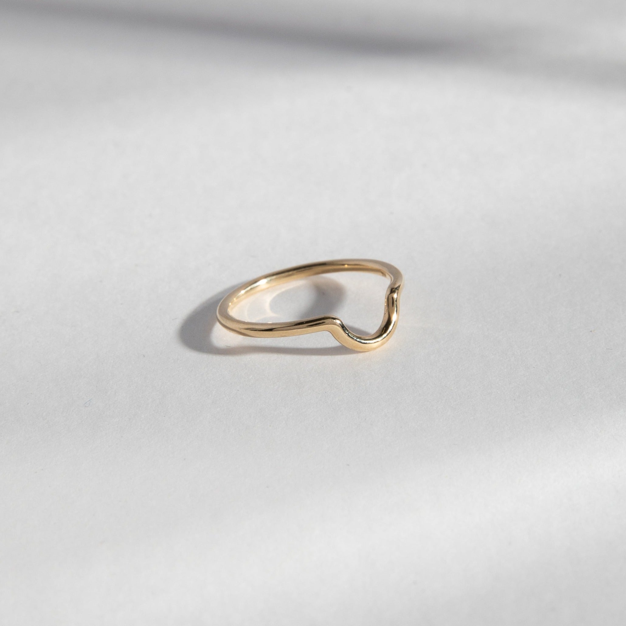Delicate gold ring showing curved front design from the side
