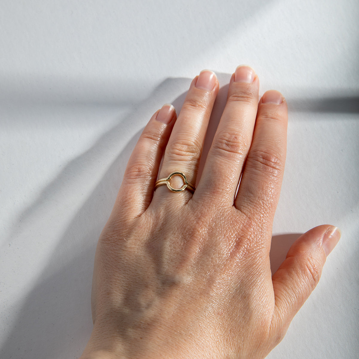 Two curved gold rings placed opposite to form a circular shape