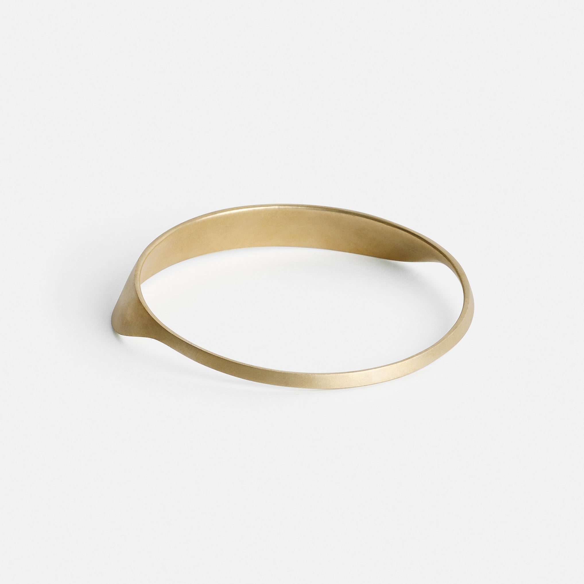 yellow brass bangle bracelet showing smooth curved structure from the back