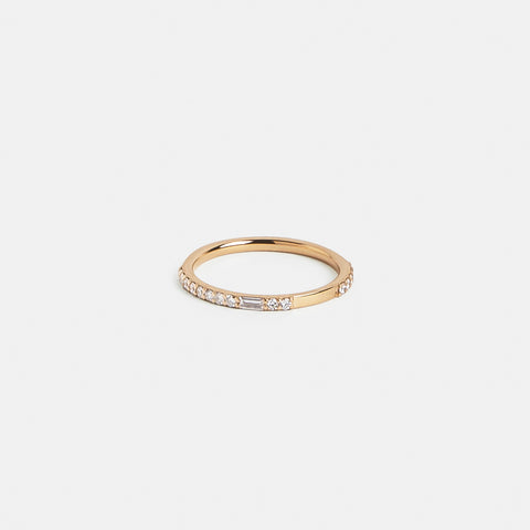 Slim gold band showing asymmetrical round and baguette diamond setting