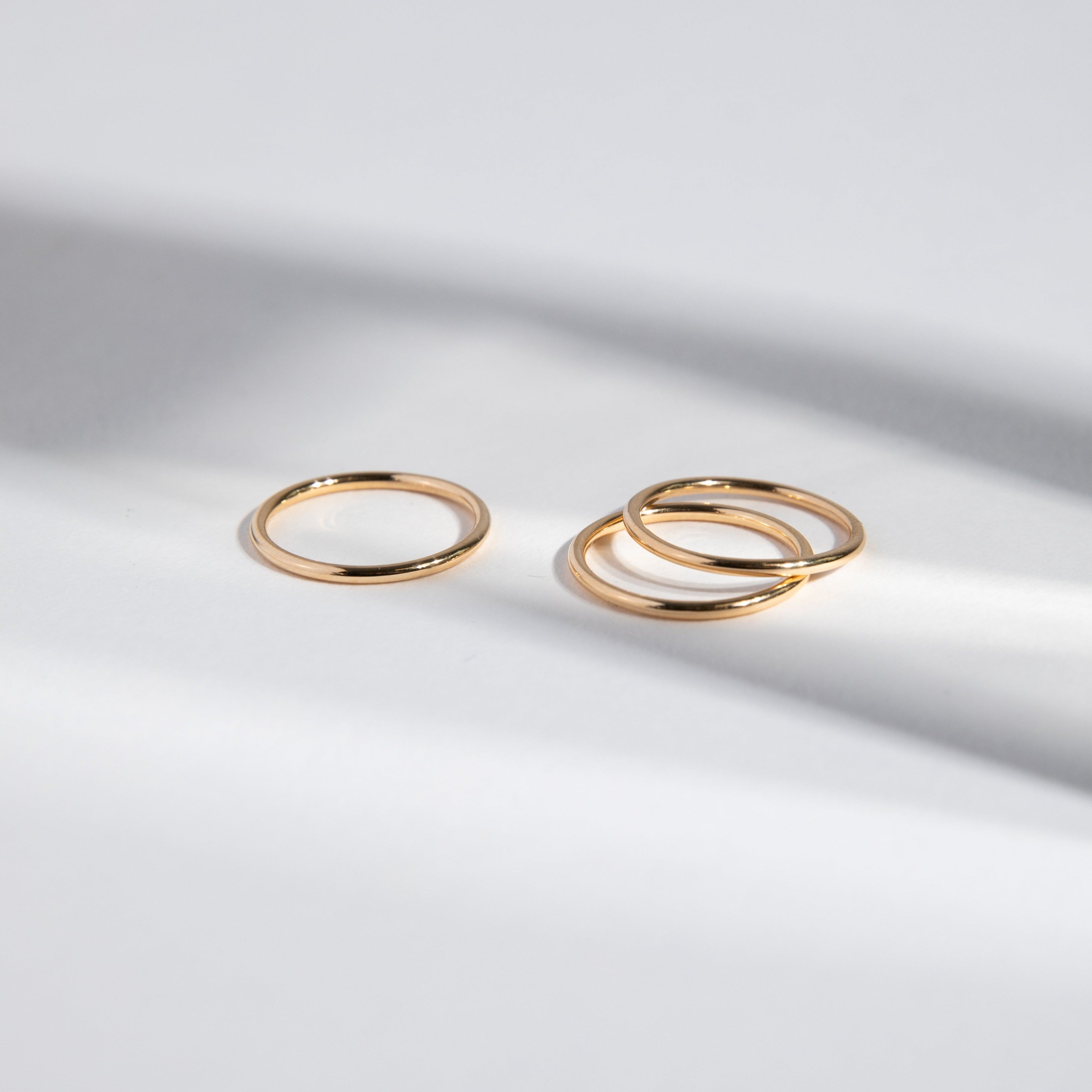 Three thin round gold bands arranged side by side